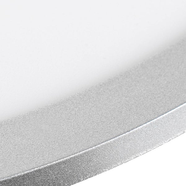 Bunter Flickenteppich vor einem Bett mit hellblauer Bettwäsche und einem orangefarbenen Polsterhocker als Beistelltisch.