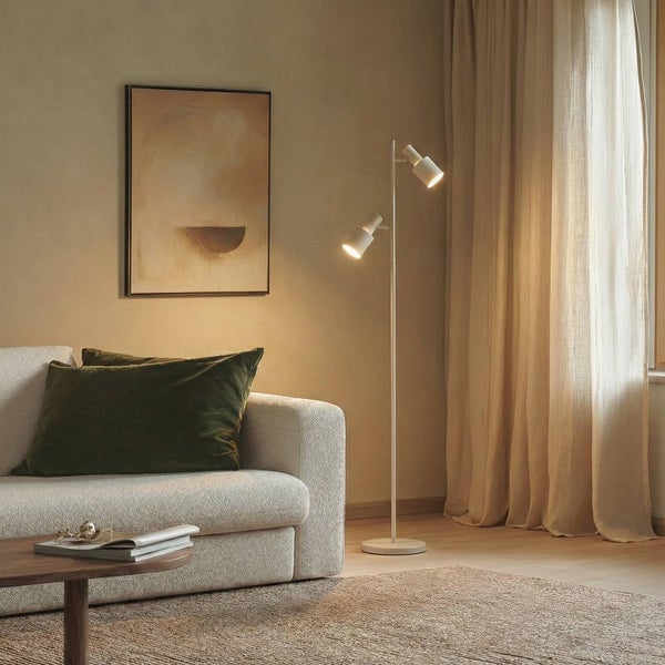 Wohnzimmer mit Sofa, Stehlampe mit zwei Strahlern und Wandbild