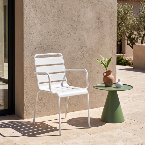 Moderner Gartenstuhl aus Metall mit Sitzfläche und Rückenlehne aus Latten sowie Armlehnen, neben einem kleinen runden Beistelltisch auf einer Terrasse.