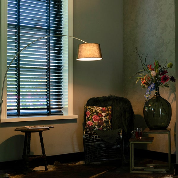 Einrichtungsidee mit Jalousie, Bogenlampe und dekorativen Elementen für ein gemütliches Ambiente