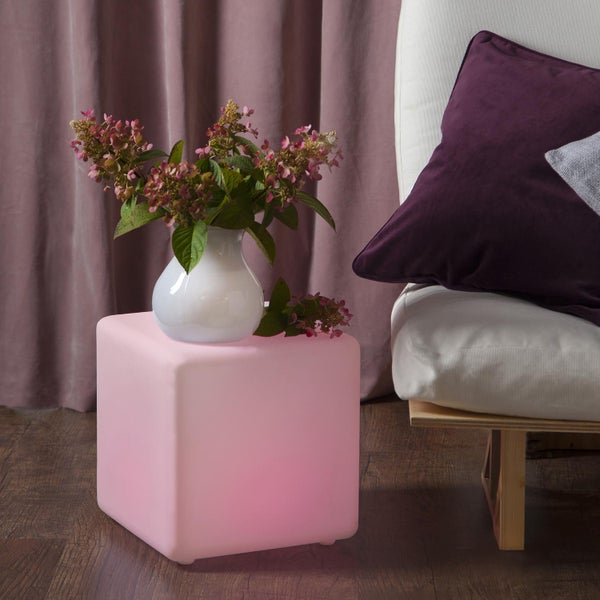 Szene mit einem Leuchtwürfel, einer Blumenvase und einem Teil eines Sofas.