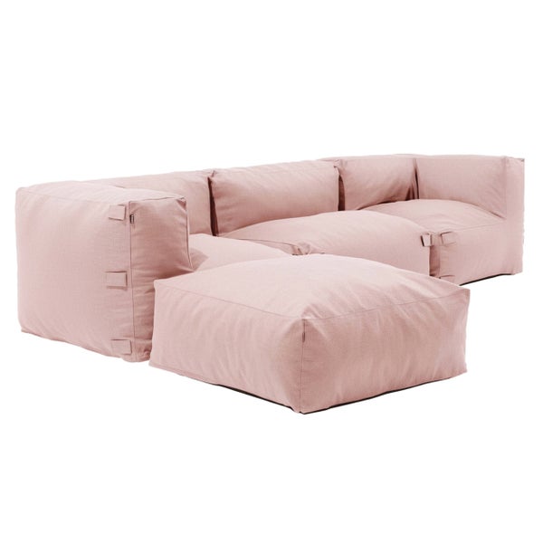 Modernes rosa modulares Outdoor-Sofa und passender Hocker auf einer Holzterrasse am Pool, umgeben von Pflanzen und Bäumen.