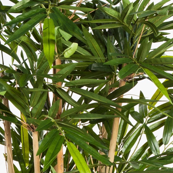 Nahaufnahme einer künstlichen Bambuspflanze mit grünen Blättern und naturfarbenen Halmen.