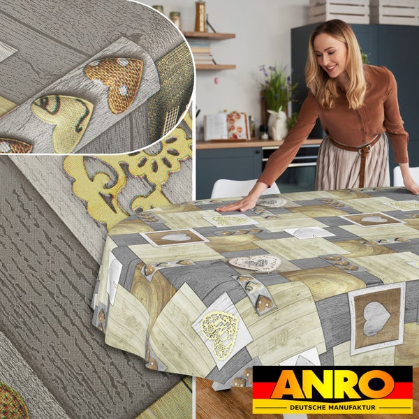 Ovale Tischdecke mit Patchwork-Muster in Holzoptik und Herzmotiven in einer Küche, inklusive Detailansicht der Stoffstruktur. ANRO Logo.