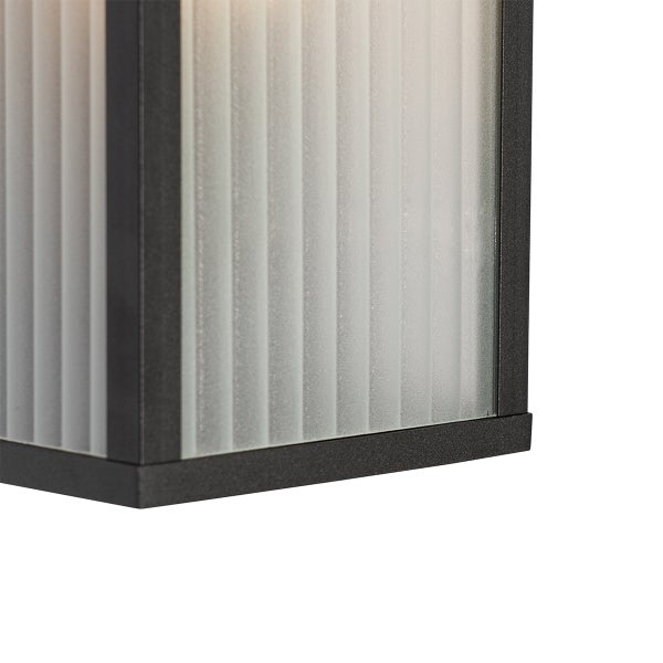 Nahaufnahme einer Außenleuchte mit schwarzem Metallrahmen und geriffeltem Mattglas.