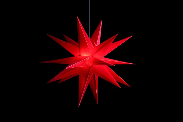 Festlich gedeckter Tisch mit Weihnachtsdekoration und roten Papiersternen