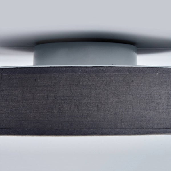 Deckenleuchte mit grauem Stoffschirm und runder Halterung in der Nahaufnahme.