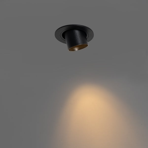 Schwarzer LED Einbaustrahler, schwenkbar, erzeugt einen warmweißen Lichtkegel.