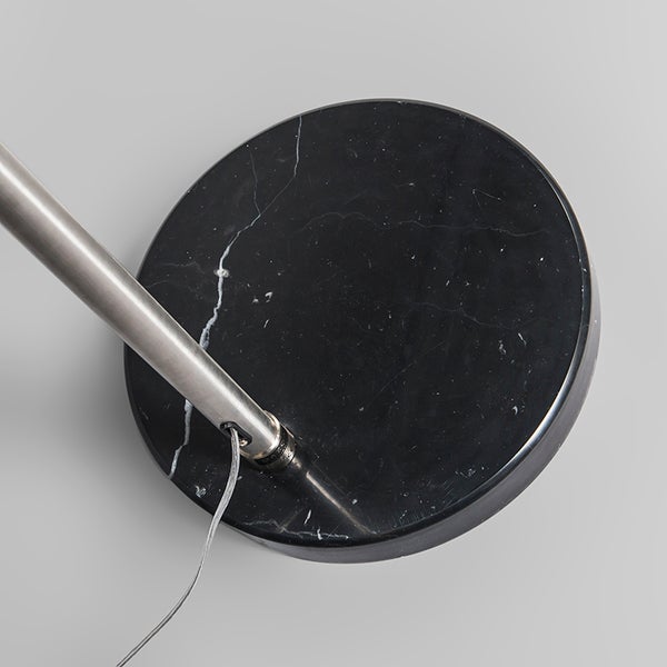 Detailaufnahme eines Lampenfußes aus Marmor mit einem Lampenrohr aus Metall