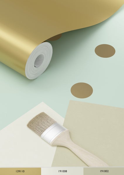 Dekorative Szene mit goldener Tapetenrolle, Pinsel und Farbfeldern