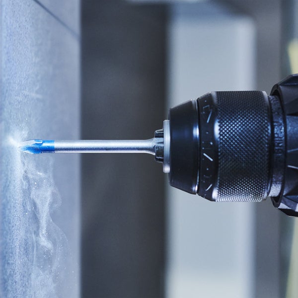 Eine Bohrmaschine bohrt ein Loch in eine Fliese.