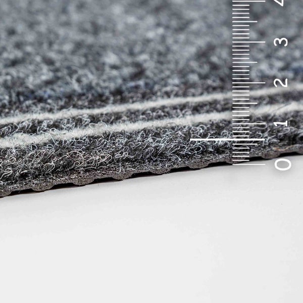 Detailansicht eines grauen Teppichs mit Messskala zur Verdeutlichung der Dicke