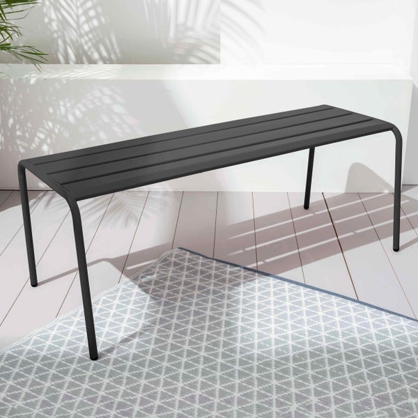 Moderne Gartenbank aus Metall in Schwarz auf einer hellen Terrasse mit einem gemusterten Outdoor-Teppich.