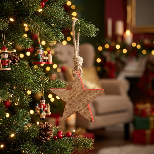 Weihnachtsbaumschmuck Stern aus Holz mit Kordel zum Aufhängen an einem geschmückten Weihnachtsbaum.