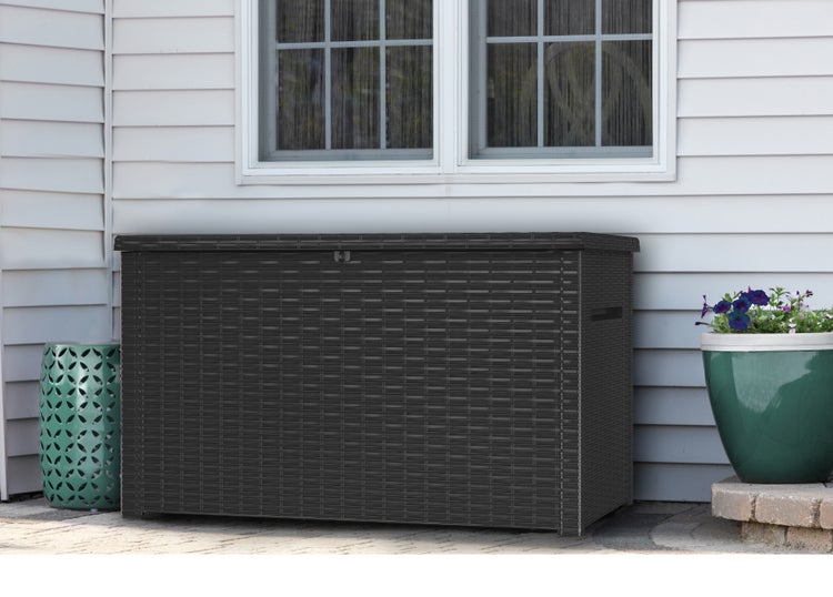 Gartenbox aus Kunststoff in Flechtoptik mit Fenster im Hintergrund