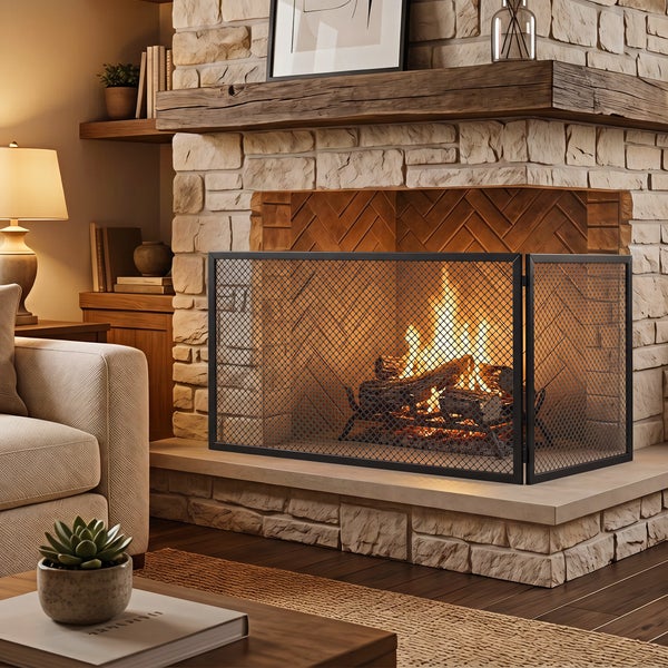 Dreiteiliger Funkenschutz aus Metall vor einem gemauerten Kamin mit brennendem Holzfeuer in einem gemütlich eingerichteten Wohnzimmer.