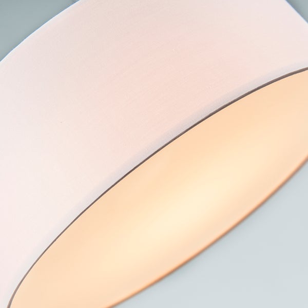 Detailansicht eines runden Lampenschirms aus Stoff mit einer metallisch glänzenden Innenseite.