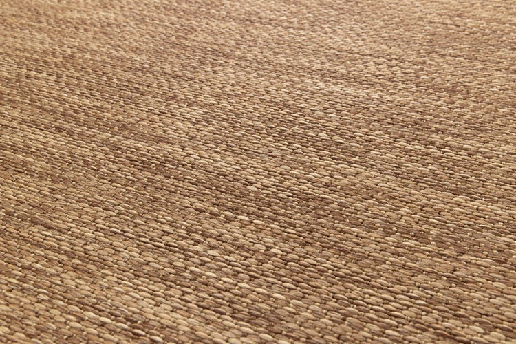 Detailaufnahme eines flachgewebten Teppichs mit strukturierter Oberfläche in Sisal-Optik.