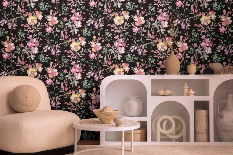 Wohnraum mit Tapete mit Blumenmuster vor einem modernen Sessel und einem Regal mit Dekorationsgegenständen.