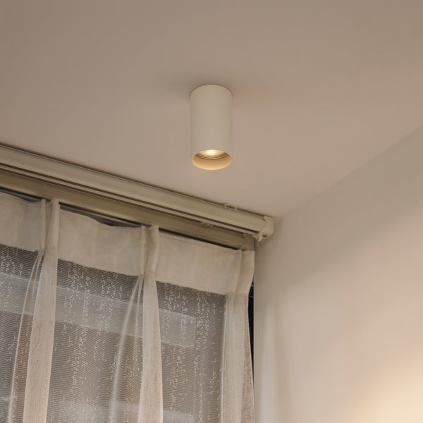 Zylindrische Deckenleuchte aus Metall im Innenraum.