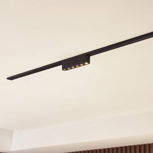 Schwarzes Schienensystem mit flachem LED-Strahler zur Deckenmontage.