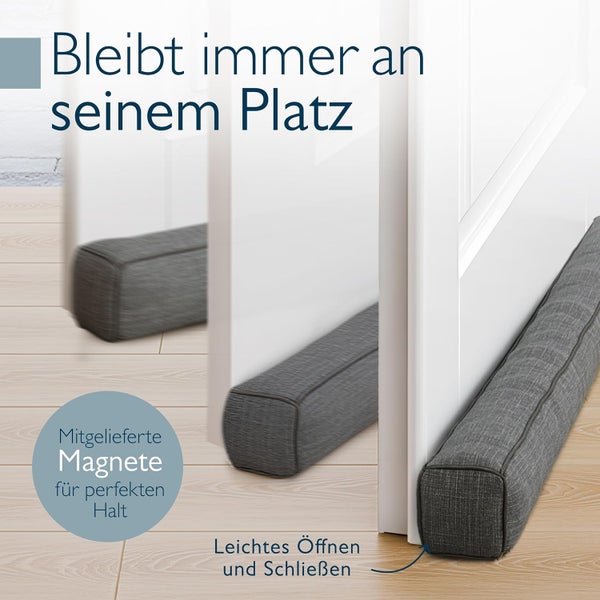 Magnetischer Zugluftstopper aus grauem Stoff an einer weißen Tür der beim Öffnen und Schließen fest an der Unterseite haftet.