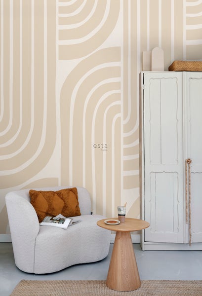 Dekoriertes Zimmer mit Sessel, Beistelltisch und Schrank vor einer gemusterten Tapete