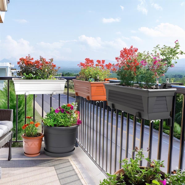 Balkonszene mit verschiedenen Blumenkästen und Blumentöpfen auf einem Balkon mit Geländer und Aussicht.