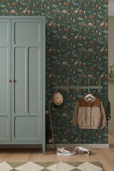 Tapete mit Dinosaurier-Motiven in einem Kinderzimmer neben einem Schrank, einer Garderobe und einem Skateboard auf Holzfußboden.