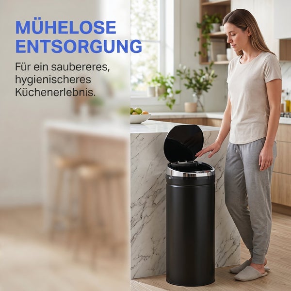 Frau bedient einen schwarzen Mülleimer mit Sensor in einer hellen, modernen Küche mit Marmorinsel.