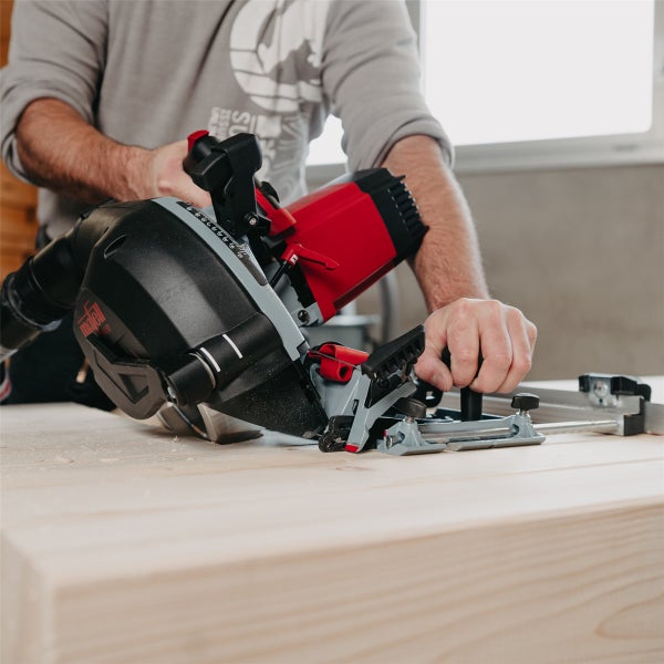 Handwerker führt eine Mafell Tauchsäge beim Sägen eines Holzbrettes in einer Werkstatt.