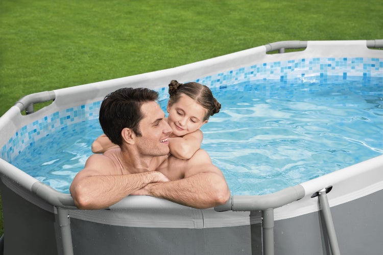 Ovaler Frame Pool mit Mosaik-Innenmuster und grauem Rand auf einer Rasenfläche mit einem Mann und einem Kind im Wasser.