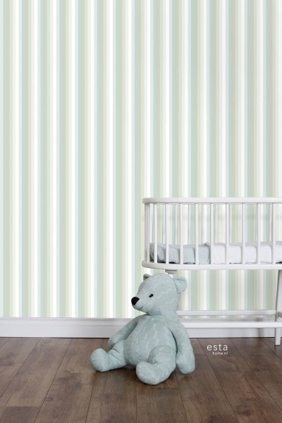 Blick in ein Zimmer mit gestreifter Tapete, einem Kinderbett und einem Teddybär.