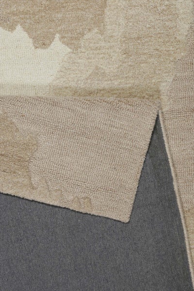 Nahaufnahme eines beigen Teppichs mit Blumenmuster, die umgeklappte Ecke zeigt die graue Rückseite.