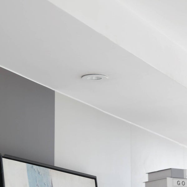 Runder LED Einbaustrahler in einer weißen Decke montiert, modernes Innendesign mit hellen und grauen Wänden.