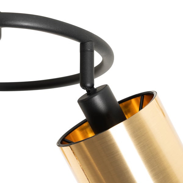 Detailaufnahme einer Deckenleuchte mit goldfarbenem Schirm und schwarzer Halterung