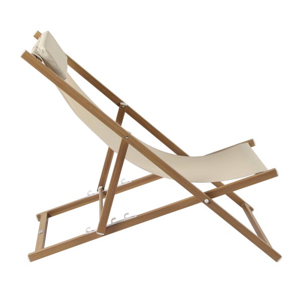 Klappbarer Liegestuhl aus Holz mit beiger Textilbespannung und Kopfkissen.