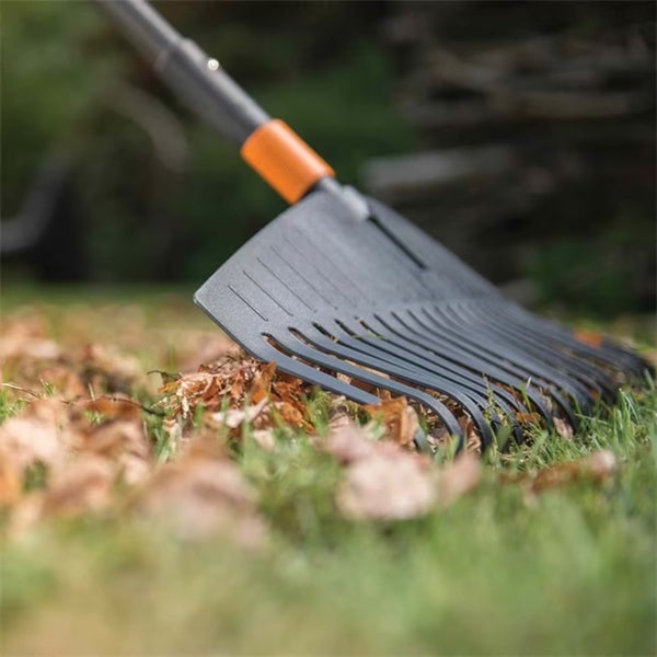 Laubbesen im Einsatz auf Rasen mit Laub