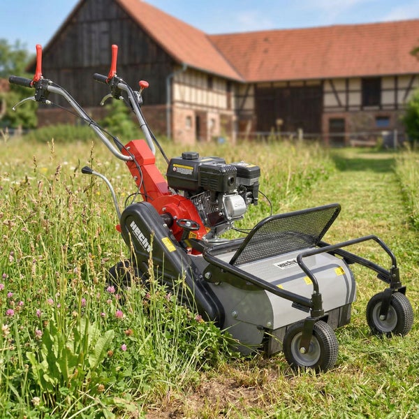 Rasenkehrmaschine auf einer Wiese vor einem Haus
