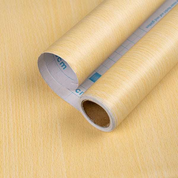 Selbstklebende Möbelfolie in heller Holzoptik, zwei Rollen, Rückseite mit Zentimeter-Raster zum einfachen Zuschneiden.