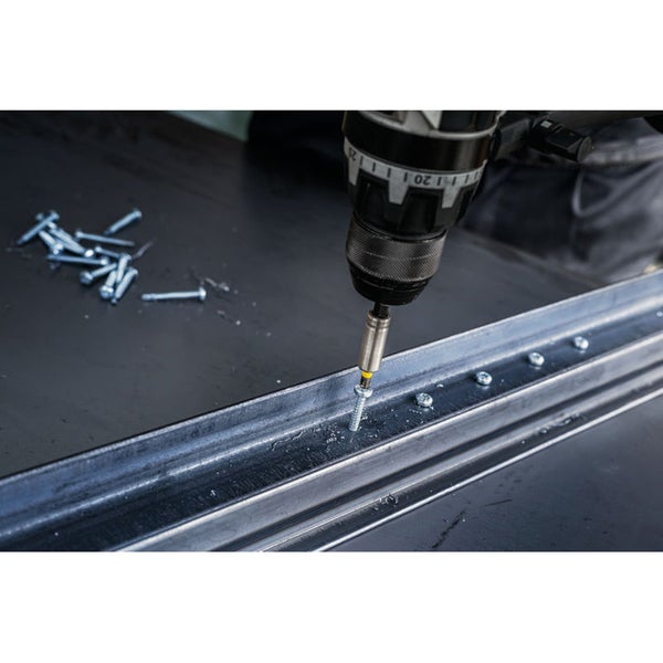 Ein Akkuschrauber schraubt eine Schraube in ein Metallprofil