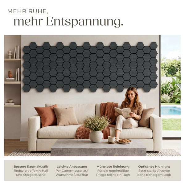 Dunkelgraue Akustikpaneele in Wabenform an einer Wand über einem Sofa in einem hellen Wohnzimmer.