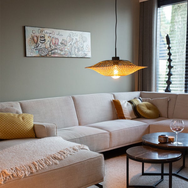 Wohnzimmer mit Ecksofa, Couchtischen und geflochtener Hängelampe für eine gemütliche Atmosphäre