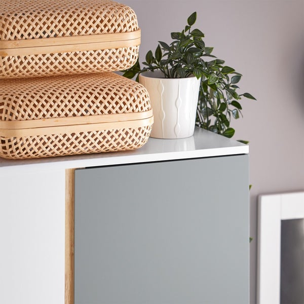 Aufnahme eines Schranks mit zwei geflochtenen Körben und einer Topfpflanze