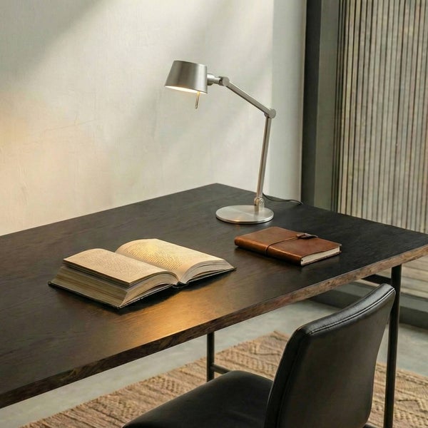 Arbeitsplatz mit Schreibtischleuchte, Notizbuch und aufgeschlagenem Buch