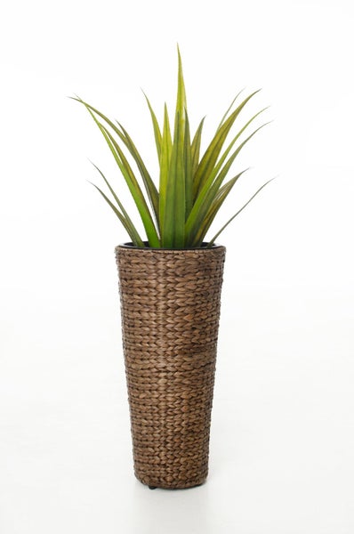 Künstliche Agave in einem hohen Pflanzgefäß aus geflochtenem Naturmaterial.