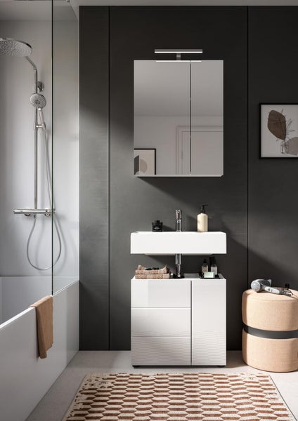 Modernes Bad mit weißem Waschtischunterschrank, Waschbecken, Spiegelschrank mit Licht sowie Duschbereich mit Glaswand und Badewanne.
