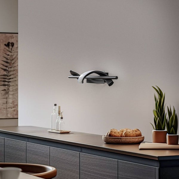 Moderne Wand-Küchenarmatur mit gebogenem Auslauf und horizontalem Griff, montiert über einer Arbeitsplatte in einer hellen Küche.