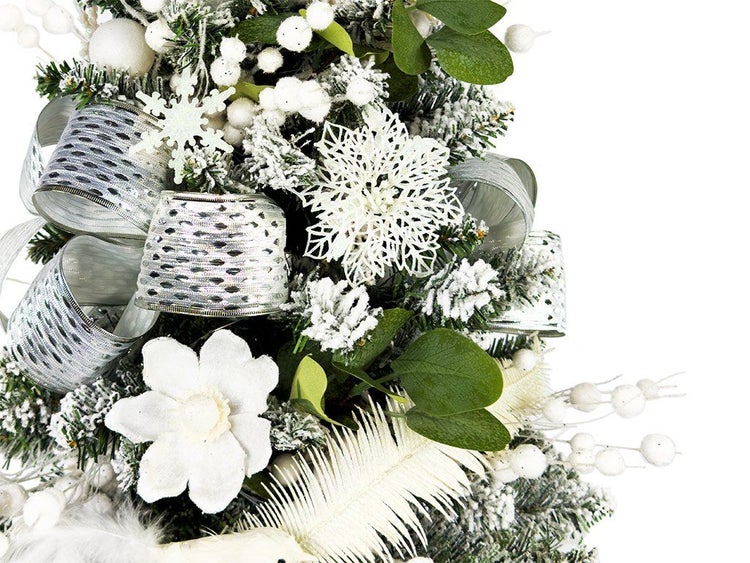 Detailansicht eines weihnachtlich geschmückten Tannenbaums mit künstlichem Schnee, Schneeflocken, Dekobändern und Blumenornamenten.