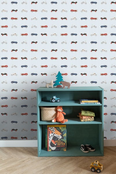 Hell gestaltetes Kinderzimmer mit gestreifter Vliestapete mit Oldtimer-Motiven, einem blauen Regal und hellem Parkettboden.
